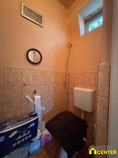 A bathroom with tiles, a mirror, and ventilation in a family house.