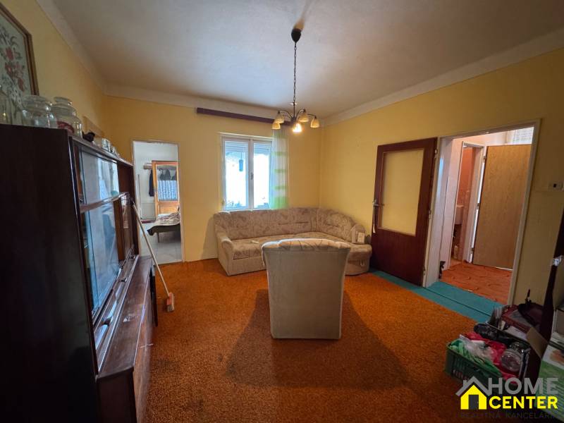 Living room of a family house with older furniture, a sofa, and a carpet.