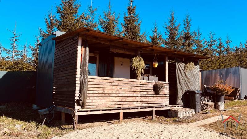 A wooden cabin surrounded by trees on Prosačov Street in the town of Prosačov, construction of houses.