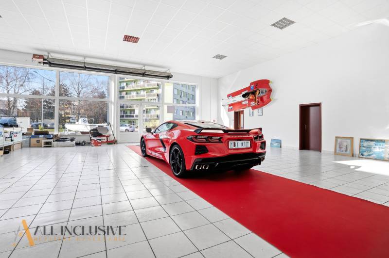 A red sports car on parquet flooring with wooden decor in commercial premises.