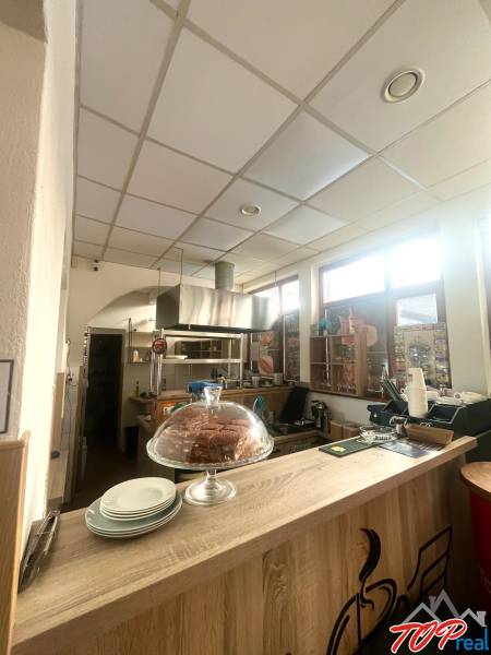 Interior of a gastro space with a wooden decor floor, counter, dessert, and plates.