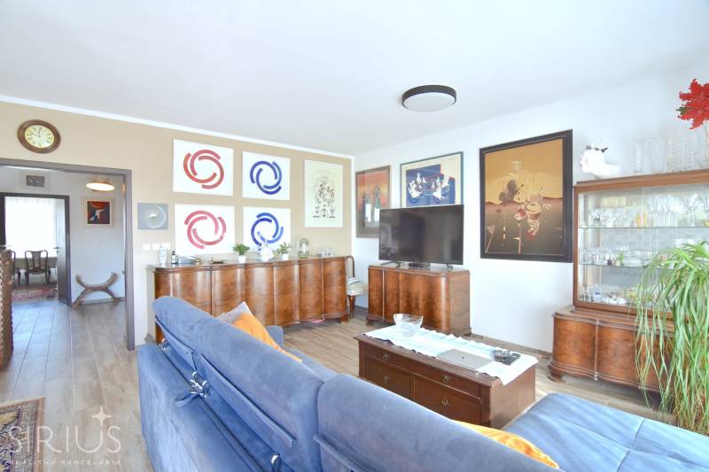 Living room in a 3-room apartment with a wooden decor floor and stylish furniture.
