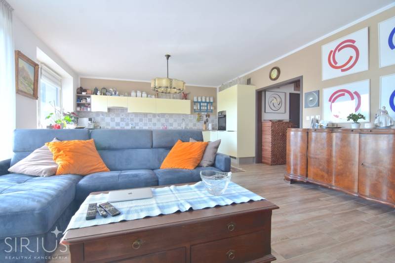Living room with a blue sofa, wooden decor flooring, 3-room apartment.