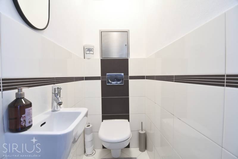 A bathroom with white tiles and sanitary ware in a 3-room apartment.