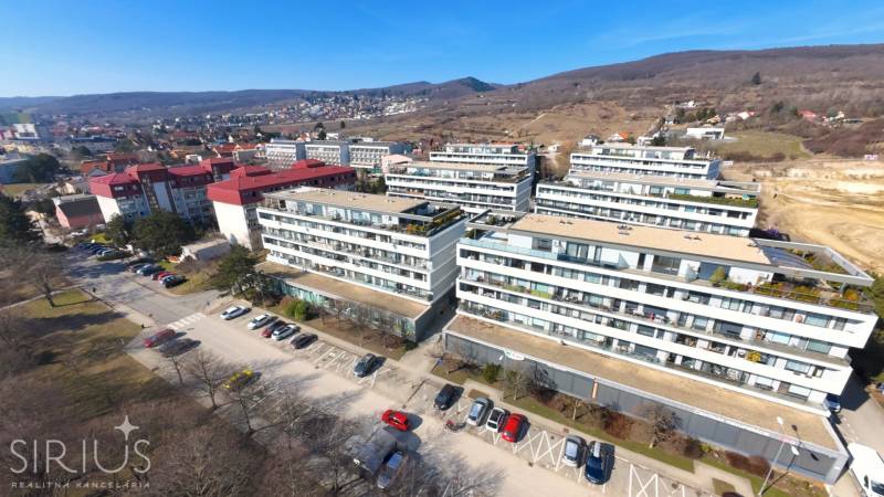 Apartment buildings on Pri vinohradoch Street in Bratislava - Rača surrounded by greenery and hills.