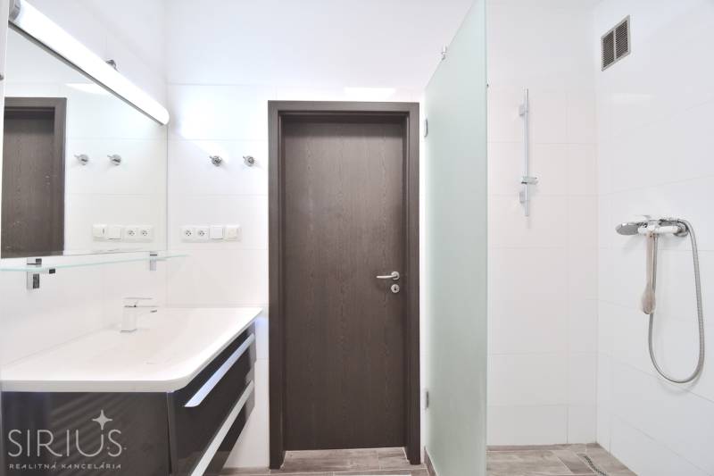 A bathroom with a shower and a glass screen in a 3-room apartment.