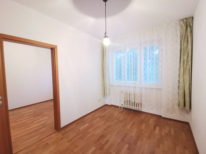 A room with curtains, a wooden floor design, and a window in a 4-room apartment.