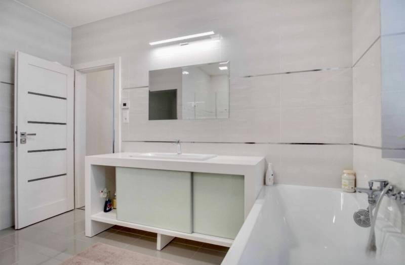 Bathroom with a bathtub and a mirror in a 3-room apartment.