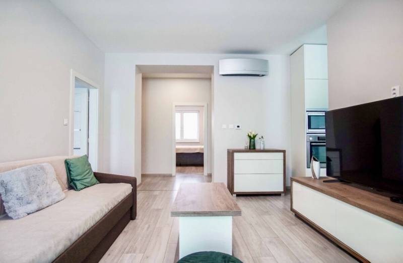 Living room in a 3-room apartment with a wooden decor floor and a comfortable sofa.