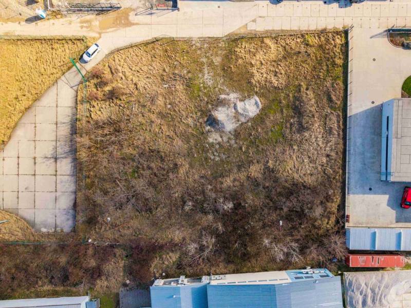 Aerial view of overgrown commercial land in Bratislava - Vajnory with adjacent buildings.