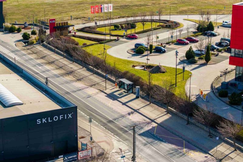 Commercial land in Bratislava-Vajnory with parking and greenery, adjacent to a cycling path.