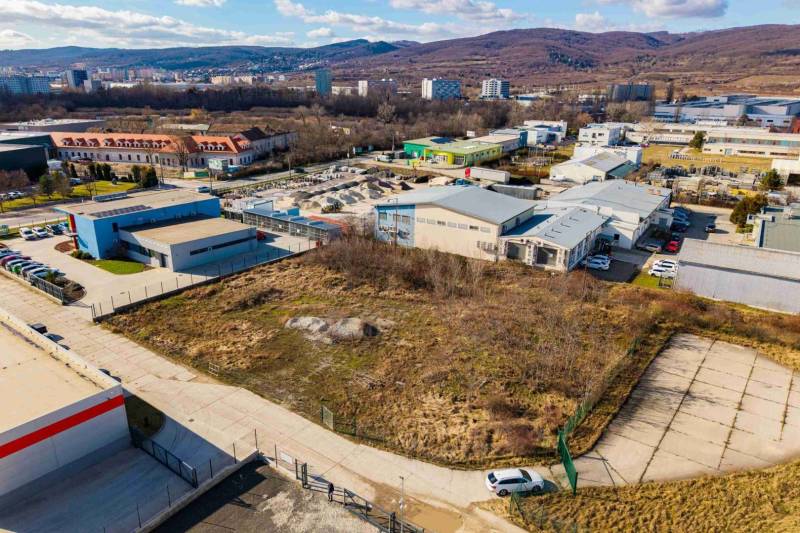 Aerial view of commercial land in Bratislava-Vajnory, surrounded by industrial buildings and greenery.