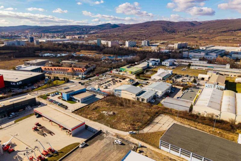 Aerial view of commercial land in Bratislava - Vajnory with industrial buildings and nature.