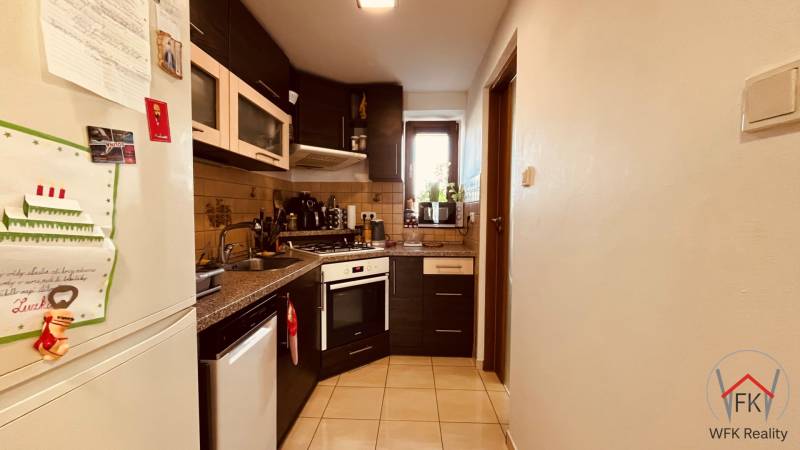 A kitchen in a 3-room apartment with a corner unit, a stove, and a tiled floor.
