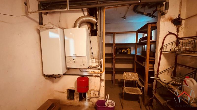 Boiler room with a boiler and shelves in the basement of a 3-room apartment.