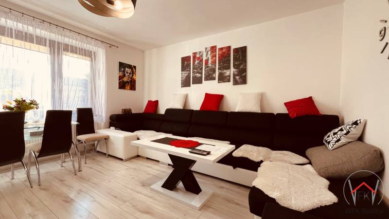Living room in a three-room apartment, with a sofa and a wooden decor floor.