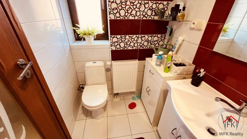 A bathroom with a toilet in a 3-room apartment, featuring white sanitary ware and decorative tiles.