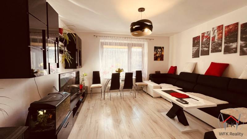 Living room with black cabinets, an aquarium, and a wood-patterned floor in a 3-room apartment.