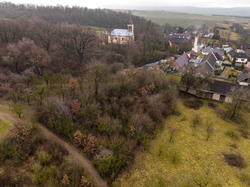Gemerské Teplice capture recreational lands with a wooded landscape and a church in the background.