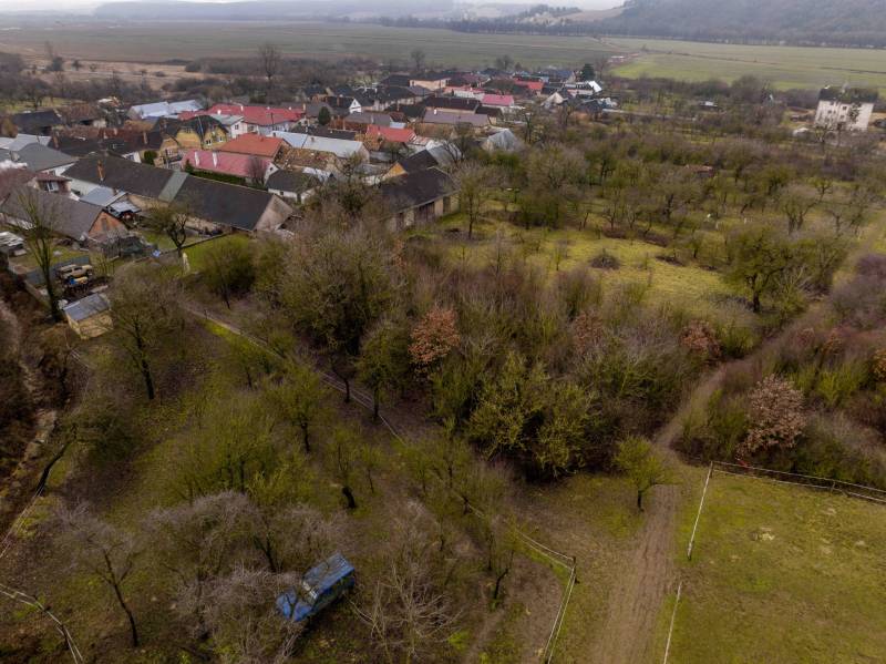 Aerial view of a village with houses and gardens surrounding the recreational grounds of Gemerské Teplice.
