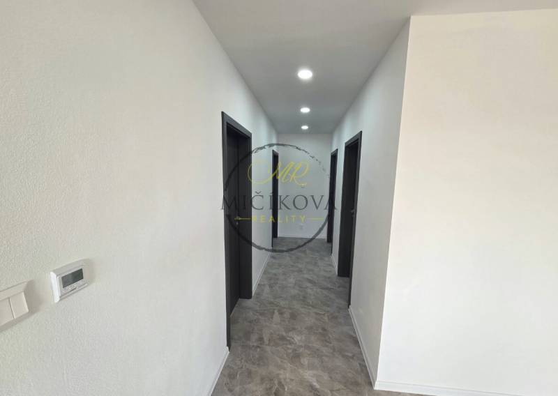 A hallway in a family house with dark doors and floor lighting with a wooden decor.