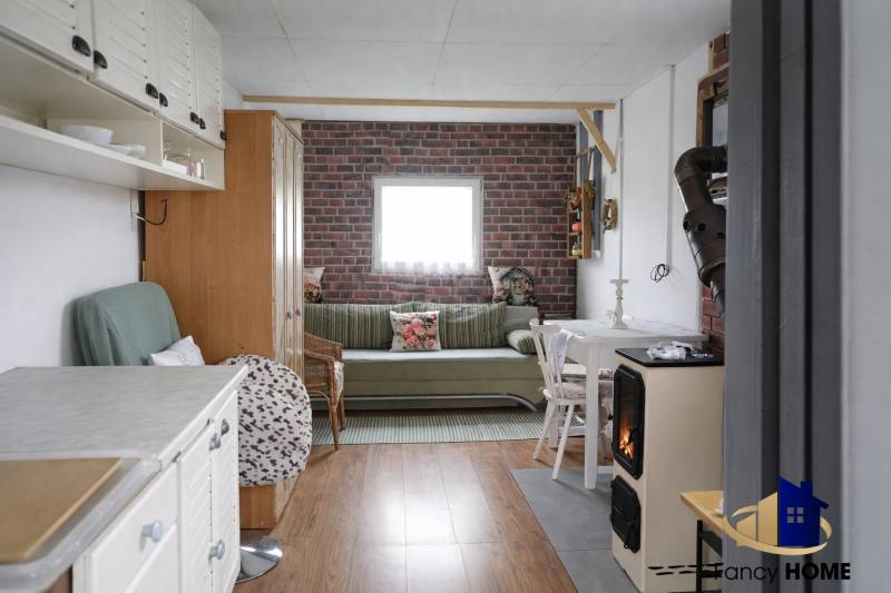 Living room with wood-patterned flooring and brick cladding, Gardens.