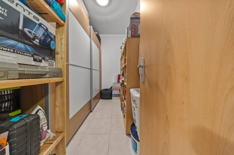 Storage space in a 4-room apartment with shelves full of household items.