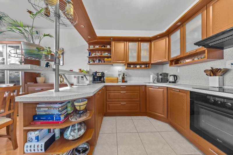 A kitchen in a 4-room apartment with a kitchen unit, open shelves, and modern appliances.