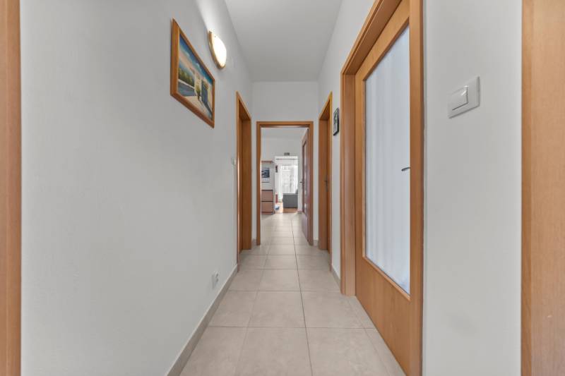 A hallway with tiles and wooden doors in a 4-room apartment.