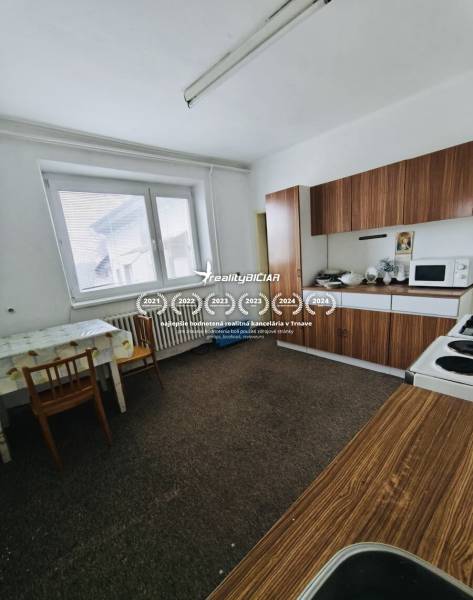 A kitchen in a family house with furniture in a wooden decor and a peaceful atmosphere.