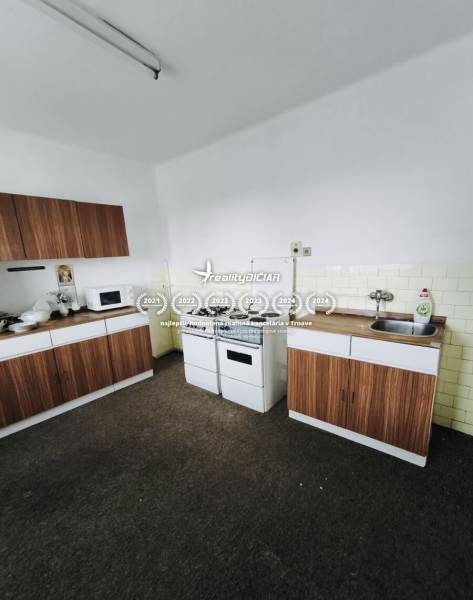 A kitchen with a gas stove, microwave, and cabinets in a family house with wooden decor.