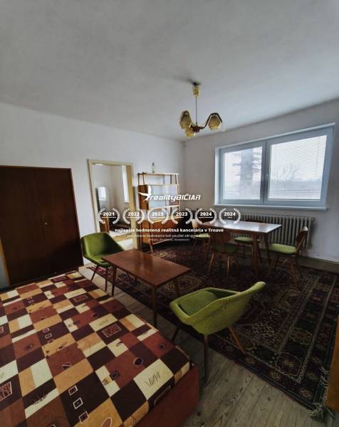 A dining room in a family house with carpets and a ceiling light, floor with wooden decor.