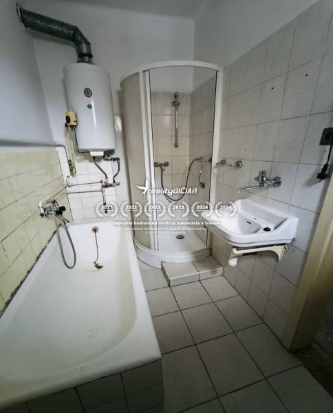 The bathroom in the family house contains a bathtub, a shower, a sink, and a boiler.