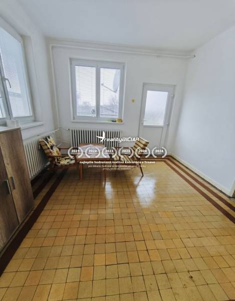 Spacious room with windows, armchairs, and tiles in a family house.