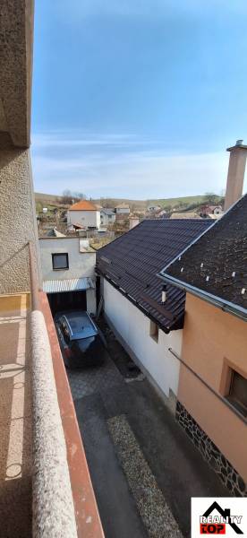 The view from the family house in Gemerský Jablonec shows the driveway and surrounding houses.