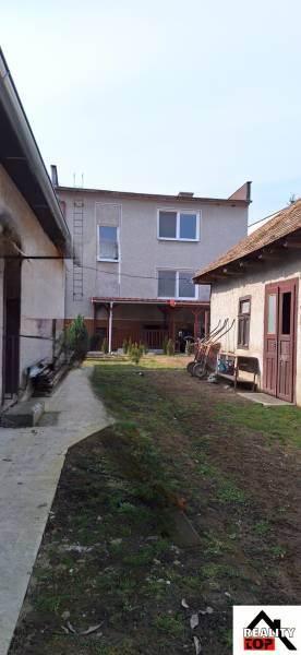 The courtyard of a family house in Gemerský Jablonec with a lawn and garden buildings.