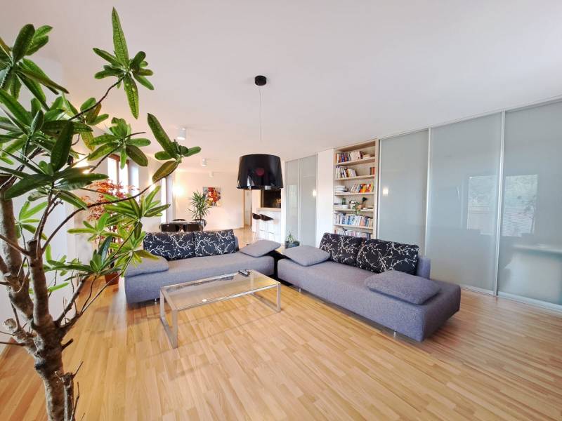 Living room in a two-room apartment with a wooden-patterned floor and a comfortable sofa.