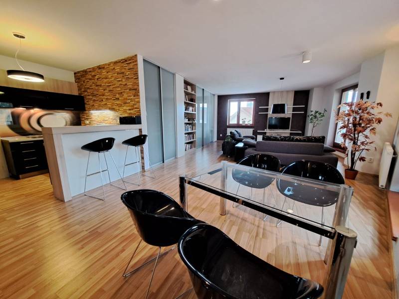 Open space of a 2-room apartment with a kitchen counter and a wooden decor floor.