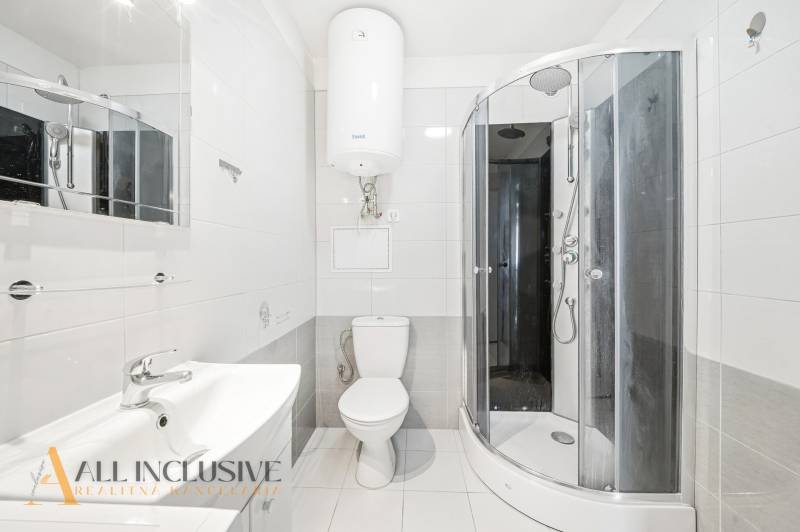 Bathroom with a shower, sink, and toilet in a 3-room apartment.