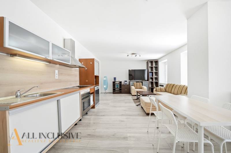 Spacious living area with kitchen in a 3-room apartment, floor with wood decor.