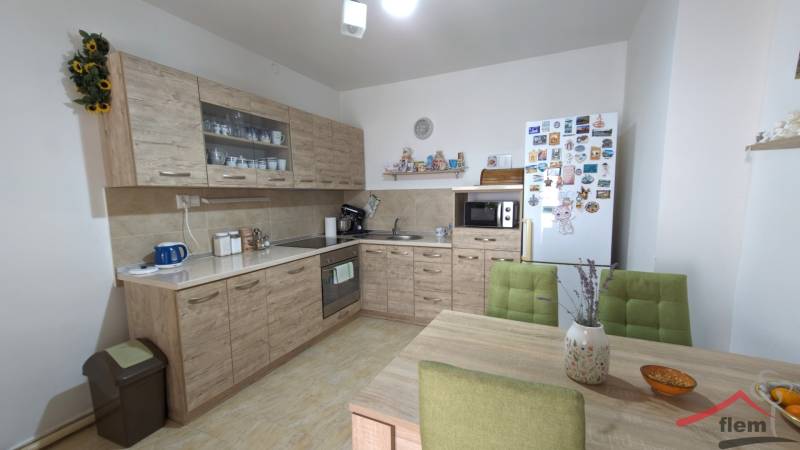 A kitchen in a family house with wooden decor furniture, green chairs, and decorations.