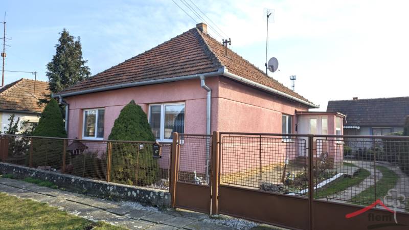 A family house on Martinová Street in Lúčnica nad Žitavou with a landscaped garden and a gate.