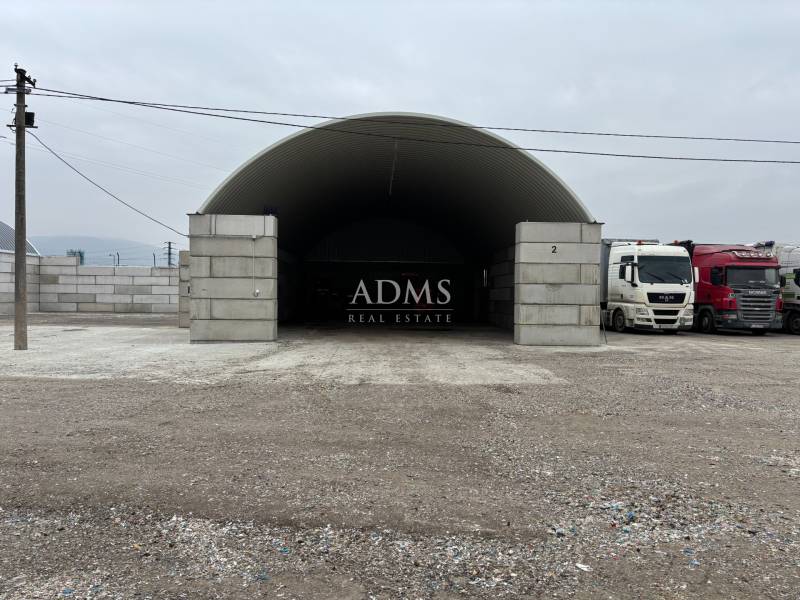 Warehouses and halls in Ladce with trucks parked in front of the arched hall.