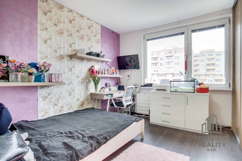 A room in a 2-room apartment with a bed, a desk, and a floor with a wooden decor.