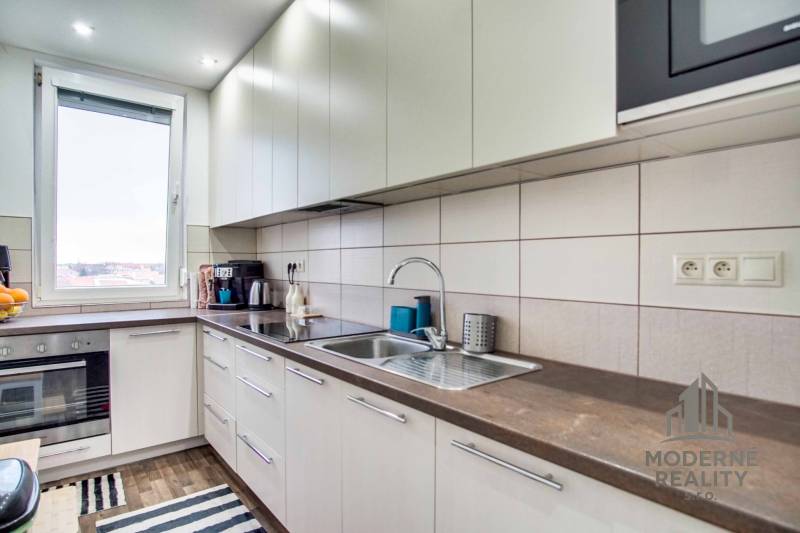 A kitchen with a spacious countertop in a 2-room apartment, with accessories on the work surface.