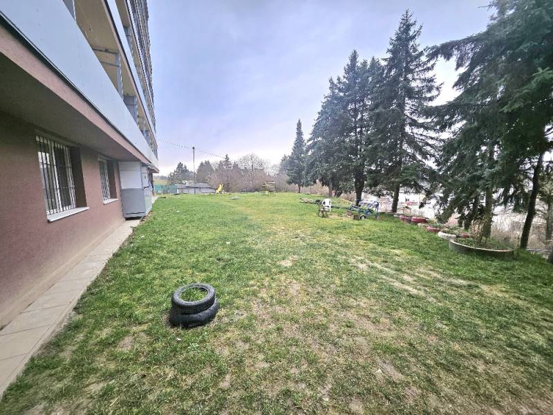 Exterior of a 3-room apartment in Bánovce nad Bebravou with a lawn and trees.