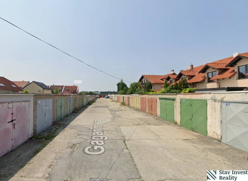Garages on Gagarin Street in Senec with neighboring houses and planted vegetation.