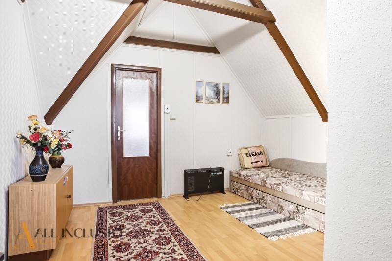 A room with a sofa, carpet, and wooden decor flooring in a cabin.