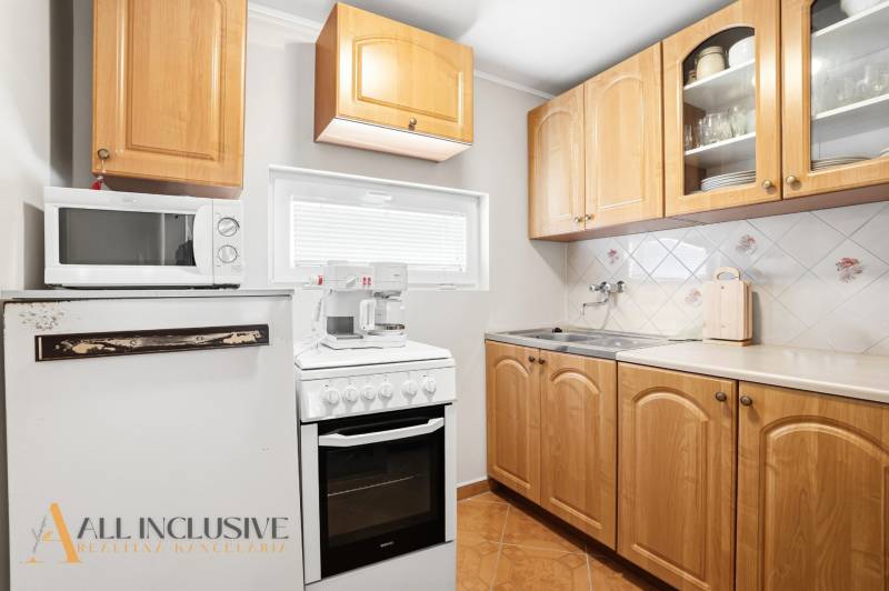 A kitchen in a cabin with wooden cabinets, a stovetop, and a microwave.