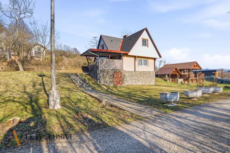 Cottage in Kováčov in Štúrovo with a grassy slope and a stone foundation.